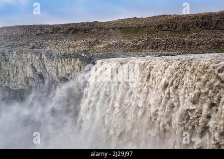 Escursionisti ai margini di Dettioss, turisti ad una gola, cascata con masse d'acqua in caduta, foschia, fiume Joekulsa a Fjoellum, Islanda settentrionale Foto Stock