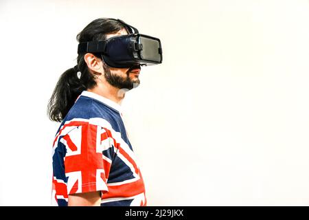 Uomo su sfondo bianco con cuffie per realtà virtuale, che testano la nuova tecnologia di realtà virtuale. Uomo con 4K occhiali che gioca o guarda video Foto Stock