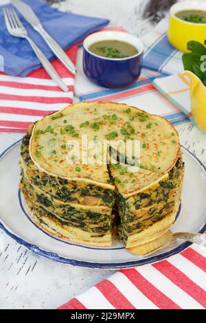 Cucina sveva, cucchiaio per torta di spinaci con pancake, flaedle stratificato, torta di pancake sul piatto, specialità sveva, salsa alle erbe sul retro, salsa Foto Stock