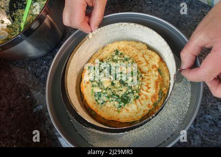 Cucina sveva, pancake, strati di pancake con miscela di spinaci, teglia a forma di springform, teglia per torte, preparazione di cucchiaino di spinaci, specialità sveva Foto Stock