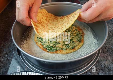 Cucina sveva, pancake, strati di pancake con miscela di spinaci, teglia a forma di springform, teglia per torte, preparazione di cucchiaino di spinaci, specialità sveva Foto Stock