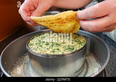 Cucina sveva, pancake, strati di pancake con miscela di spinaci, teglia a forma di springform, teglia per torte, preparazione di cucchiaino di spinaci, specialità sveva Foto Stock