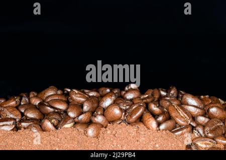 I chicchi di caffè di qualità arabica si trovano sul caffè macinato Foto Stock
