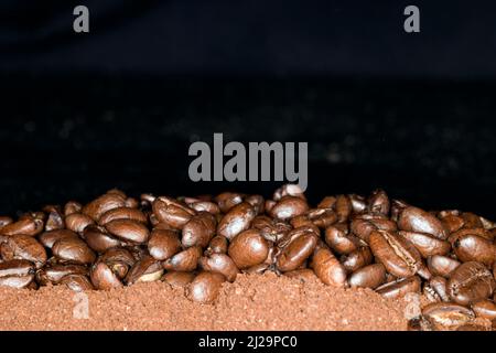 I chicchi di caffè di qualità arabica si trovano sul caffè macinato Foto Stock