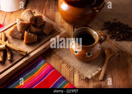 Cafe de Olla. Caffè messicano tradizionale e ingredienti di base per la sua preparazione, caffè, cannella e piloncillo, servito in una tazza di argilla chiamata 'jarr Foto Stock