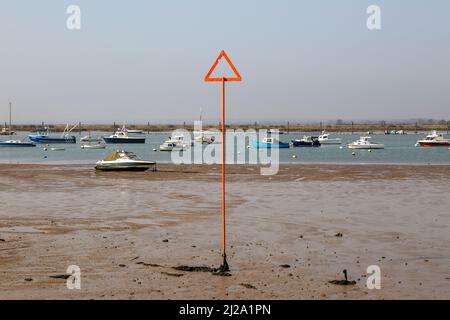 Cartello di navigazione con triangolo arancione in bassa marea, estuario del fiume Blackwater, West Mersea, Mersea Island, Essex, Inghilterra, Regno Unito Foto Stock
