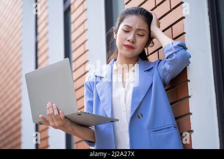Giovane donna asiatica che lavora fuori Foto Stock