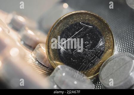 Una moneta da euro su una confezione di pillole Foto Stock