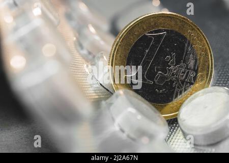 Una moneta da euro su una confezione di pillole Foto Stock