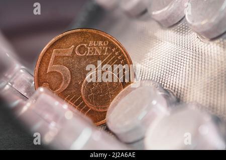 Moneta da cinque centesimi di euro su una confezione di pillole Foto Stock