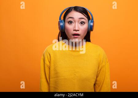 Attraente stupito donna asiatica sorpresa con bocca aperta larga scioccato dal film mentre guardando spaventato alla macchina fotografica. Attraente signora asiatica bruna sinistra stordito senza parole mentre si sente tragica notizia. Foto Stock