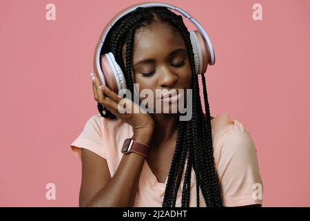 Bella giovane donna che balla e ascolta la musica in cuffie rinfrescarsi suoni Foto Stock