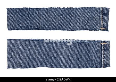 Primo piano di due pezzi tagliati di zampe di un jeans blu denim isolato su sfondo bianco. Macro. Foto Stock