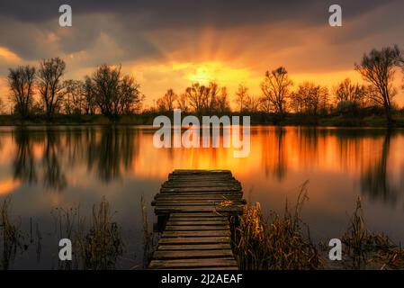 Una splendida vista sul tramonto da un molo sul lago Foto Stock