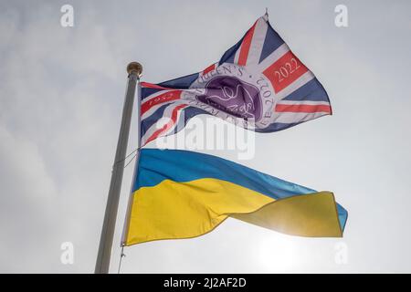 La bandiera Platinum Jubilee Union Jack vola su un palo insieme alla bandiera bicolore della Repubblica popolare Ucraina con cielo chiaro chiaro chiaro alle spalle Foto Stock