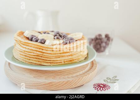 Delizioso dolce cibo dessert frittelle o frittelle di farina di mais, prodotto dietetico, cibo dolce, cottura vacanza. Pancake con mirtilli freschi, banana e hone Foto Stock