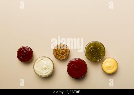 Diversi tipi di salse in ciotole su un pannello colorato . Vista dall'alto, vari salse copia spazio. Foto Stock