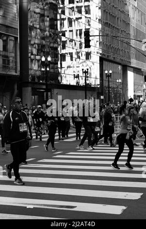 Corridori che corrono la maratona Chicago St Patrick’s Day in bianco e nero. Foto Stock