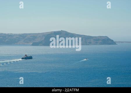 Santorini, Grecia - 10 maggio 2021 - Un traghetto più grande e un traghetto più piccolo accanto ad esso lasciando il porto di Athinios a Santorini Foto Stock