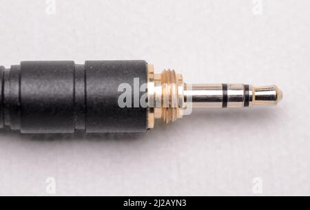 3,5mm connettore jack per cuffie stereo e cavo per segnali audio analogici su sfondo bianco Foto Stock