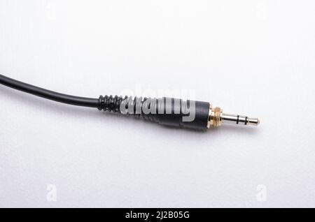 3,5mm connettore jack per cuffie stereo e cavo per segnali audio analogici su sfondo bianco Foto Stock