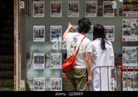 Hong Kong. 30th Mar 2022. Una coppia guarda gli elenchi di bene immobile. I prezzi delle abitazioni abitate di Hong Kong sono al loro livello più basso in due anni, con preoccupazioni per la quinta ondata di COVID-19 e altri indicatori economici che portano a ulteriori riduzioni dei prezzi. (Foto di ben Marans/SOPA Images/Sipa USA) Credit: Sipa USA/Alamy Live News Foto Stock