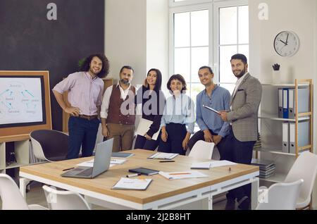 Ritratto del team aziendale felice e di successo radunato nella sala riunioni Foto Stock