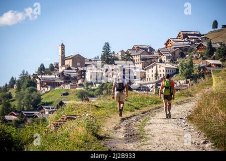 Saint-Veran (Francia sud-orientale): Due escursionisti visto da dietro a piedi su un sentiero che conduce al villaggio, nel Queyras Parco Naturale Regionale Saint- Foto Stock