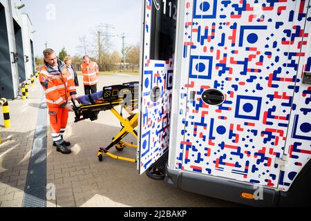 31 marzo 2022, Brandeburgo, Angermünde: David Sohn, paramedico a Johannitre-Unfall-Hilfe Angermünder, dimostra una barella motorizzata per impieghi pesanti durante la presentazione della prima ambulanza di Brandeburgo con il "design anti-gaffer". Johannitre-Unfall-Hilfe ha messo in funzione un'ambulanza con "design anti-Gaffer". In questo modo, Johannitre-Unfall-Hilfe vuole impedire le riprese del telefono cellulare da parte dei gaffer a gravi incidenti. Foto: Christoph Soeder/dpa Foto Stock