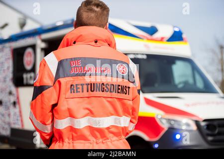 31 marzo 2022, Brandeburgo, Angermünde: Un paramedico si trova di fronte alla prima ambulanza di Brandeburgo con un "design anti-Gaffer". Johannitre-Unfall-Hilfe ha messo in funzione un'ambulanza con "design anti-Gaffer". Con questo, Johannitre-Unfall-Hilfe vuole impedire le riprese del telefono cellulare da parte dei gaffer a gravi incidenti. Foto: Christoph Soeder/dpa Foto Stock