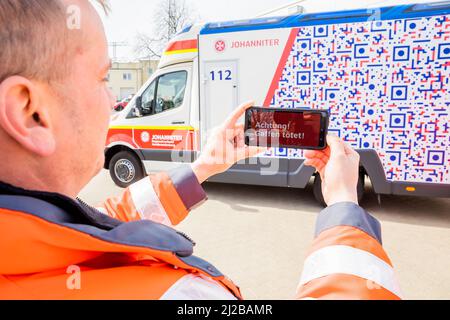 31 marzo 2022, Brandeburgo, Angermünde: David Sohn, paramedico di Johannitre-Unfall-Hilfe Angermünder, utilizza uno smartphone per dimostrare come funziona la prima ambulanza di Brandeburgo con un "design anti-gaffer". Johannitre-Unfall-Hilfe ha messo in funzione un'ambulanza con "design anti-Gaffer". In questo modo, Johannitre-Unfall-Hilfe vuole impedire le riprese del telefono cellulare da parte dei gaffer a gravi incidenti. Foto: Christoph Soeder/dpa Foto Stock