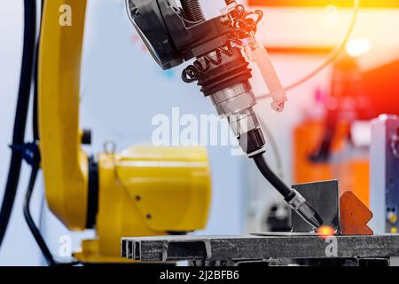 Robot industriale a braccio CNC saldatura automatica produzione di metalli in fabbrica. Foto Stock