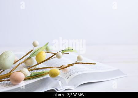 bibbia bianca con tulipani bianchi e decorazioni delle uova di pasqua su legno bianco con spazio copia Foto Stock