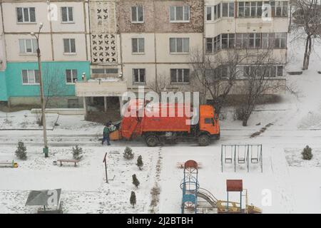 Lavoratori di camion di rifiuti. Rimozione di rifiuti in zona residenziale, gli uomini di rifiuti che caricano rifiuti domestici in camion di rifiuti Foto Stock