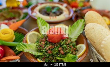 Diversi antipasti libanesi e insalate insieme sul tavolo. Focalizzato sul tabbouleh Foto Stock