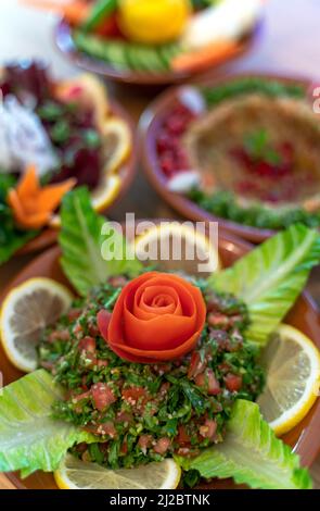 Diversi antipasti libanesi e insalate insieme sul tavolo. Focalizzato sul tabbouleh Foto Stock