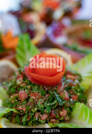 Diversi antipasti libanesi e insalate insieme sul tavolo. Focalizzato sul tabbouleh Foto Stock
