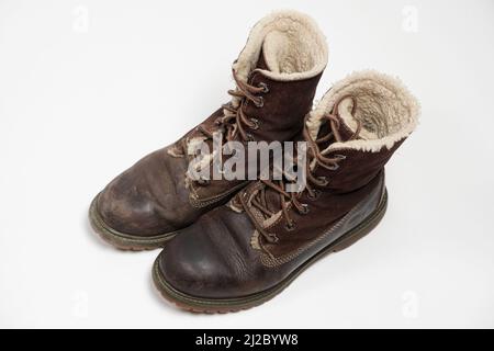Stivali nubuck marroni - uno sporco, il secondo pulito su sfondo bianco. Cura delle scarpe. Foto Stock