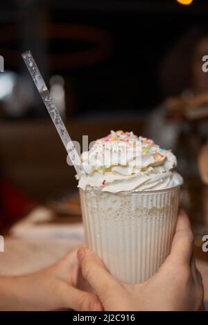 Frullato glassato al cioccolato con ciambelle e dolci. Folle freakshake alimentare tendenza. Spazio di copia Foto Stock