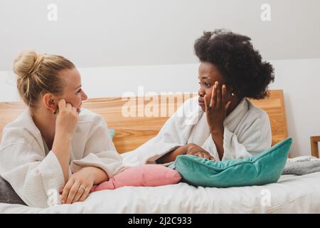 I migliori amici si rilassano al centro benessere e discutono dei segreti Foto Stock