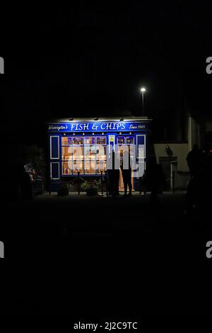 Nel piccolo villaggio di Wessington nel Derbyshire, i clienti di Dales sono in attesa alla luce della sera per ordinare i loro pesci e chip cena Foto Stock