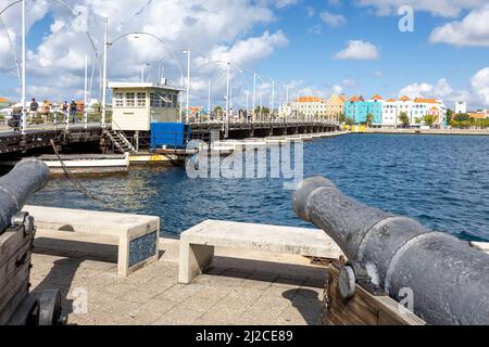 Cannone che indica il famoso ponte della regina emma e gli edifici di Otrobanda a Willemstad, Curacao Foto Stock