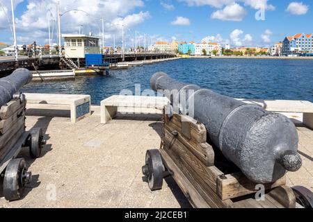 Cannone che indica il famoso ponte della regina emma e gli edifici di Otrobanda a Willemstad, Curacao Foto Stock