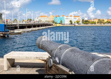 Cannone che indica il famoso ponte della regina emma e gli edifici di Otrobanda a Willemstad, Curacao Foto Stock