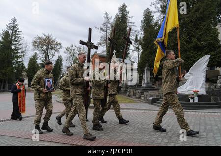 Lviv, Ucraina. 31st Mar 2022. I militari ucraini marciano con un ritratto di un soldato ucraino ucciso e attraversa durante la sepoltura. Cerimonia funeraria di 3 soldati ucraini Kozachenko Andriy, Sarkisyan Ihor, Oliynyk Yuriy uccisi dalle forze russe durante l'invasione russa a Lviv. (Credit Image: © Mykola TYS/SOPA Images via ZUMA Press Wire) Foto Stock