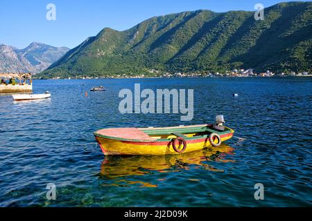 La colorata barca si riflette sulle acque della Baia di Cattaro, Montenegro Foto Stock