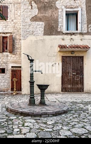 Fontana d'acqua con pompa manuale nel centro storico di Kotor, Montenegro Foto Stock