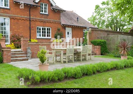 Grande casa di campagna o casa, con giardino sul retro, patio e mobili in legno. Inglese paesaggistico, giardino terrazzato design Foto Stock