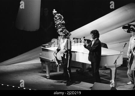 Elton John in concerto durante il suo Ice on Fire Tour, nella foto si esibisce alla Wembley Arena. Elton, che indossa una torreggiante corona, è Unito sul palco da George Michael. 19th dicembre 1985. Foto Stock