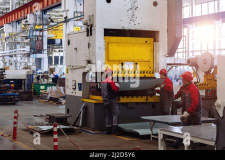 Operatori tecnici che lavorano con lamiera su pressa idraulica CNC. Foto Stock